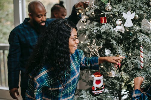 性格开朗的黑人家庭，享受圣诞节装饰品 · 免费素材图片