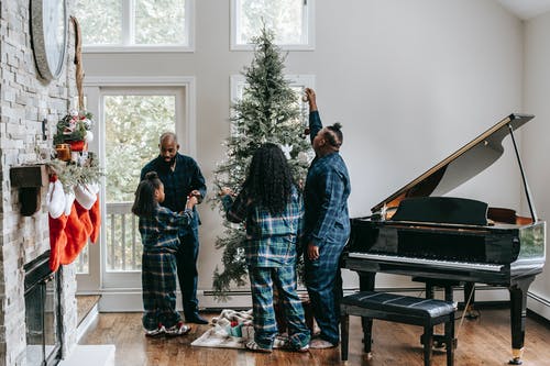 黑人家庭一起装饰圣诞树 · 免费素材图片