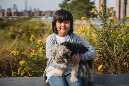 可爱的亚洲孩子与宠物在花园里 · 免费素材图片