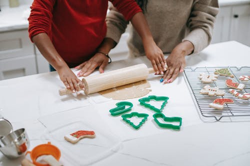 裁剪黑人孩子帮助母亲铺开面团的糕点 · 免费素材图片