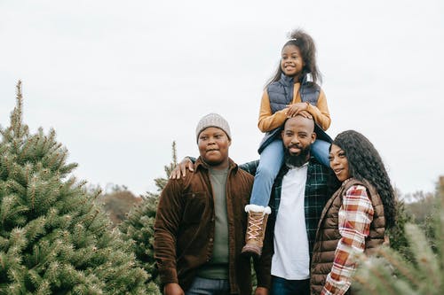 一起选择杉树的快乐的黑人家庭 · 免费素材图片