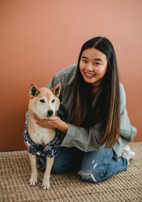 幸福的亚洲女人拥抱可爱的狗 · 免费素材图片