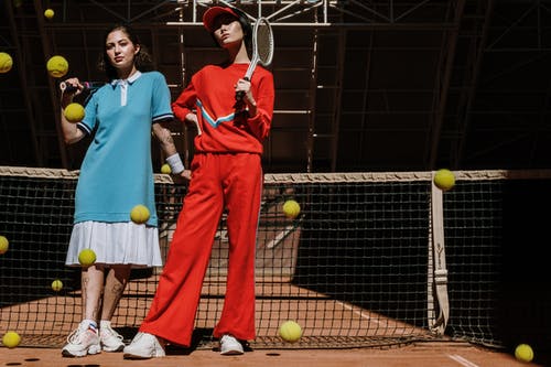 红色polo衫和红色裤子拿着网球拍的人 · 免费素材图片