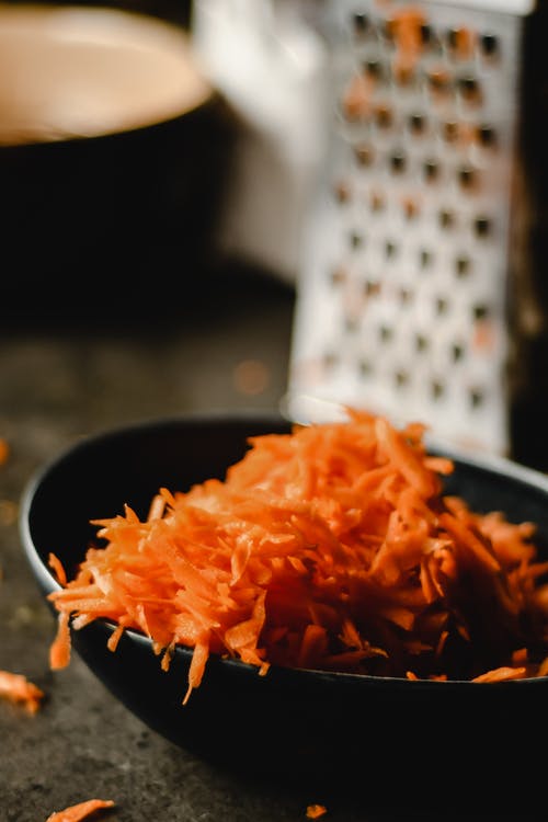 黑色陶瓷碗配橙色面食 · 免费素材图片