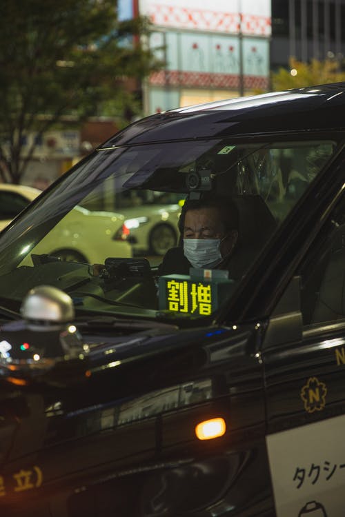 亚裔在汽车的人佩带的面具 · 免费素材图片