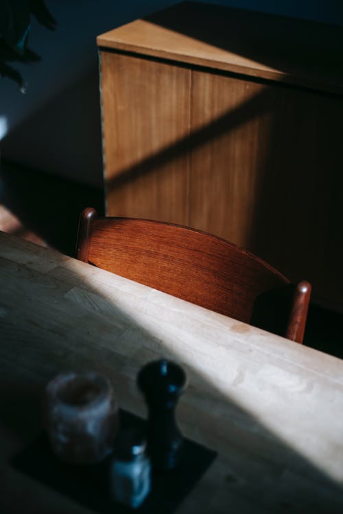 白色桌子旁边的棕色木椅 · 免费素材图片