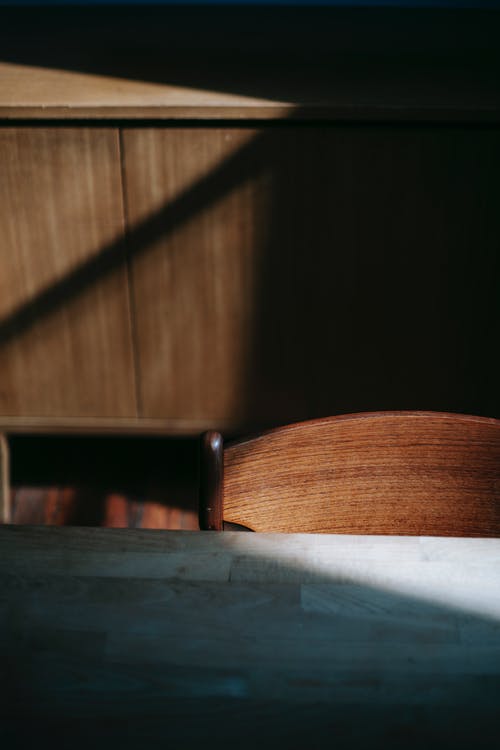 桌子旁边的棕色木椅 · 免费素材图片
