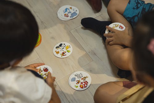 一群族裔儿童玩带插图卡的游戏 · 免费素材图片