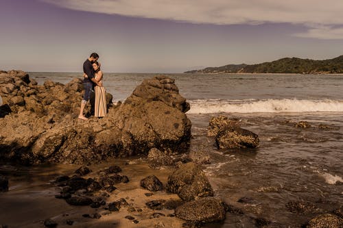 有关一对, 人, 多岩石的海滩的免费素材图片