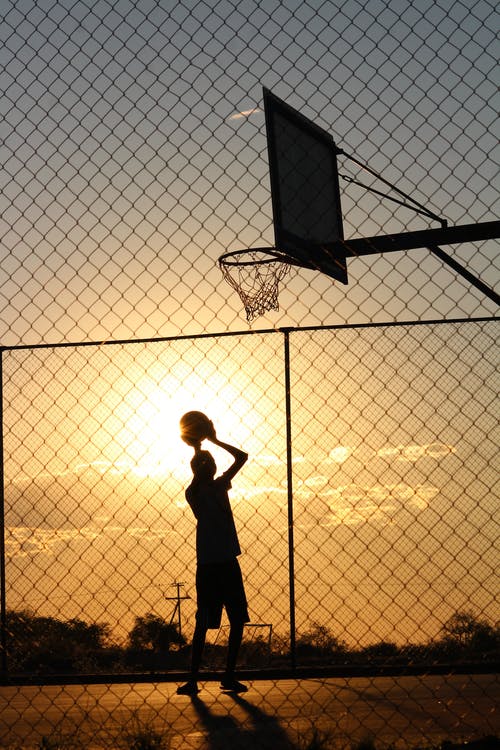 篮球运动员把球扔进篮球筐 · 免费素材图片