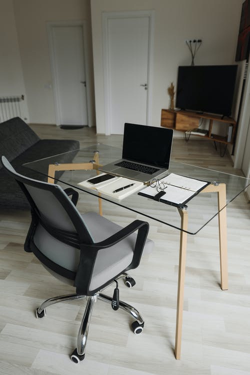 黑色滚动椅子上桌上的银色macbook · 免费素材图片