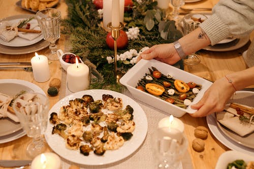 在圣诞大餐上供应食物的人 · 免费素材图片