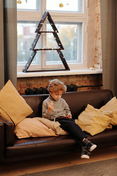 男孩坐在沙发上 · 免费素材图片
