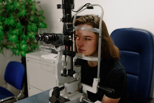 女人在诊所的现代设备上测试视觉 · 免费素材图片