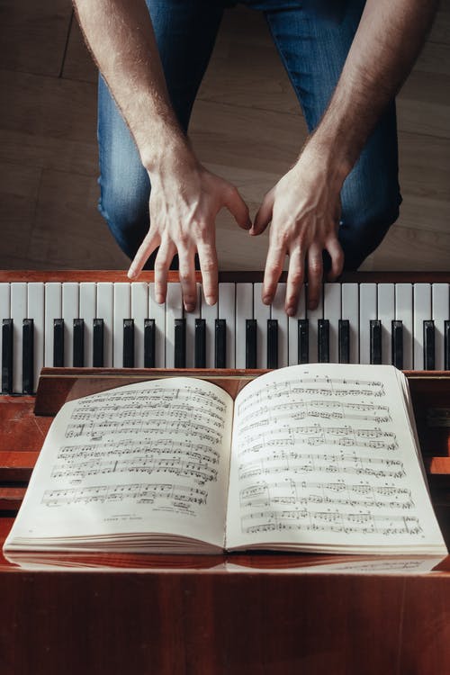 作物钢琴家弹钢琴，乐谱架上 · 免费素材图片
