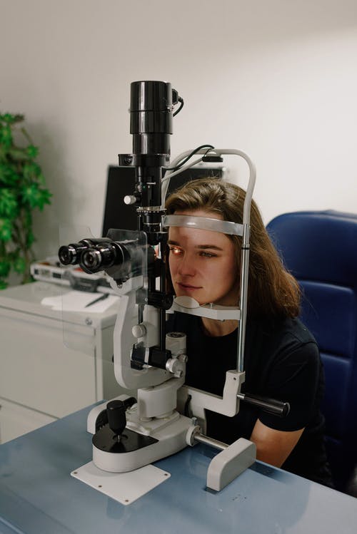 女人在眼科诊所对现代设备的测试愿景 · 免费素材图片