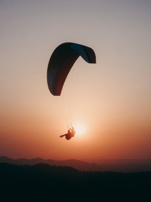 滑翔伞在落日的天空中飞翔 · 免费素材图片