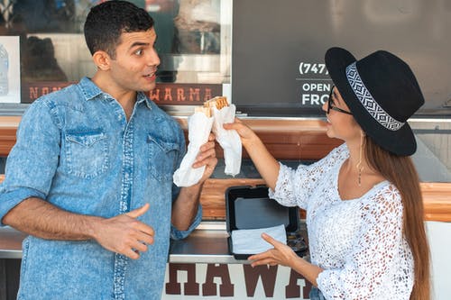 快乐的夫妻在食品卡车附近无比的三明治 · 免费素材图片