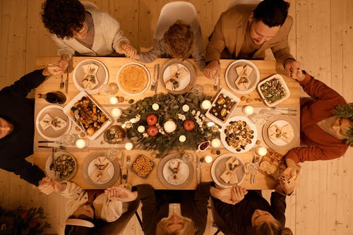 一个家庭在圣诞节晚餐前祈祷的顶视图 · 免费素材图片