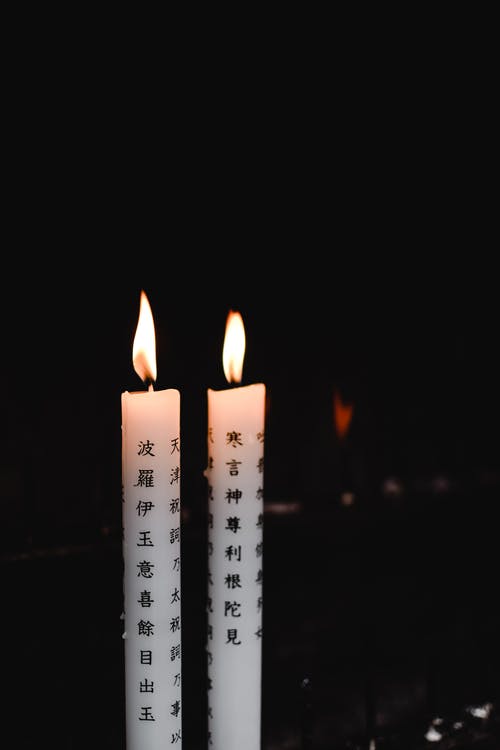 黑色背景上的白色蜡烛 · 免费素材图片