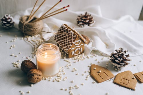 棕色和白色巧克力棒旁边棕色木棍和白色蜡烛 · 免费素材图片