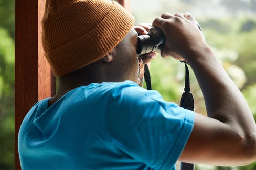 黑人用双筒望远镜在家 · 免费素材图片