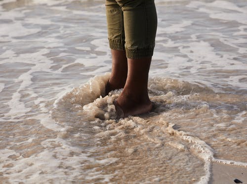 在海岸与泡沫海洋水作物黑人游客 · 免费素材图片