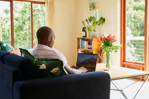 学习和在笔记本电脑上阅读的黑人男子 · 免费素材图片