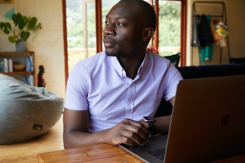 集中在桌上的笔记本电脑的黑人男子 · 免费素材图片