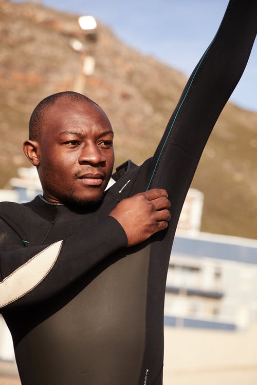 梦幻般的黑人运动员，穿着潜水服在海滩上 · 免费素材图片