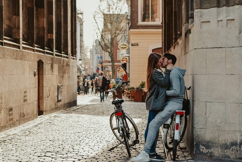 浪漫的情侣与自行车在旧街上接吻 · 免费素材图片