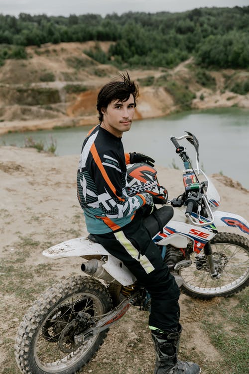 黑色和橙色夹克骑摩托车的人 · 免费素材图片