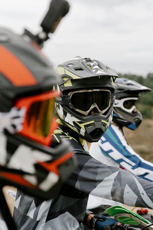 黑色和橙色头盔和黑色和橙色头盔的人 · 免费素材图片