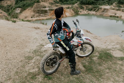 黑色和红色夹克骑越野摩托车越野自行车的人 · 免费素材图片