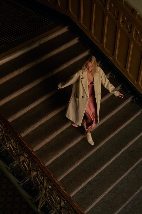 白色外套在楼梯上走下来的女人 · 免费素材图片