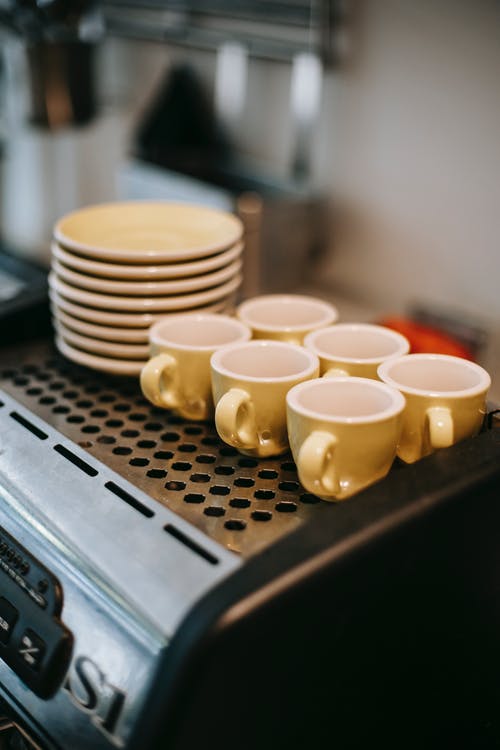 咖啡机上的杯子和碟子 · 免费素材图片