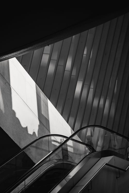 在现代建筑与阴影墙附近的自动扶梯 · 免费素材图片