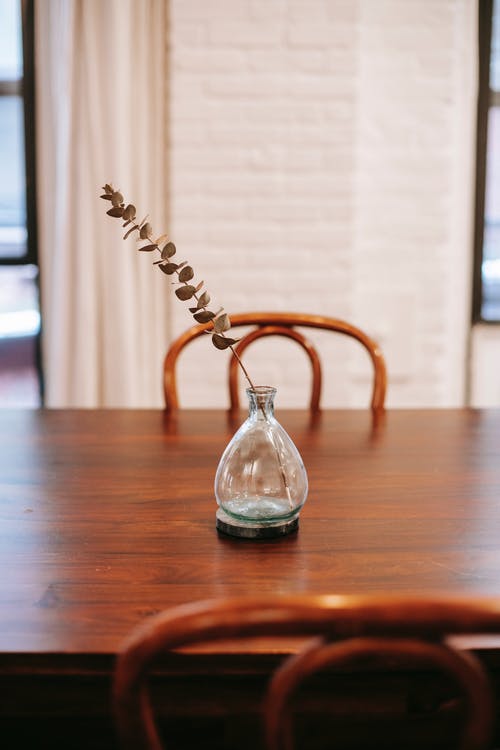 玻璃花瓶与干植物木制的桌子上 · 免费素材图片