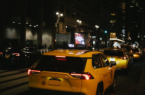 夜间在城市街道上行驶的掀背车出租车 · 免费素材图片