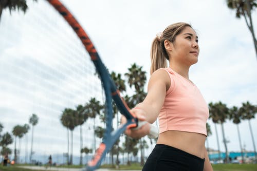 粉色背心和黑色短裤拿着网球拍的女人 · 免费素材图片