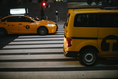 晚上在大街上行驶的各种闪亮的黄色出租车 · 免费素材图片