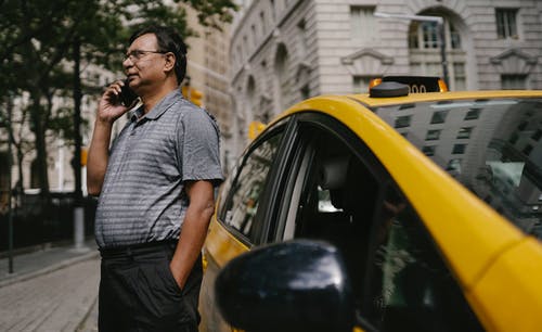 浅谈智能手机站在出租车附近的民族男子 · 免费素材图片