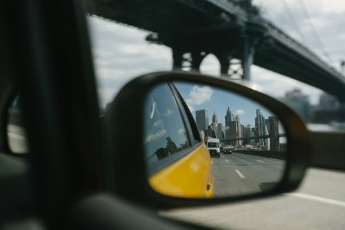在桥上行驶的汽车的后视镜中的反射 · 免费素材图片