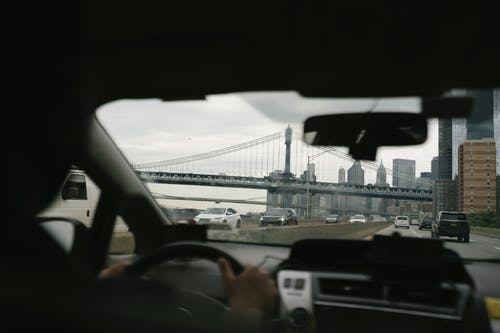 不可识别的人驾驶汽车在大都市 · 免费素材图片