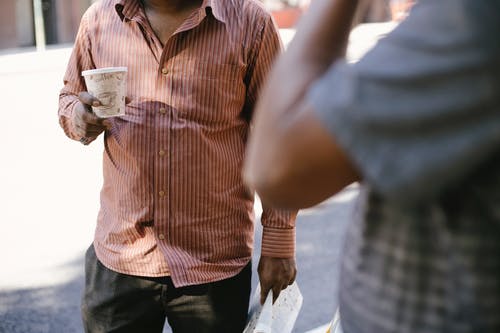 与外卖咖啡在城市巷道上互动的不露面民族朋友 · 免费素材图片