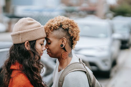多种族的女同性恋夫妇站在城市的街道上关闭 · 免费素材图片