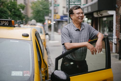 性格开朗的出租车司机站在车旁 · 免费素材图片