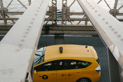 在金属桥上驾驶的黄色出租车 · 免费素材图片