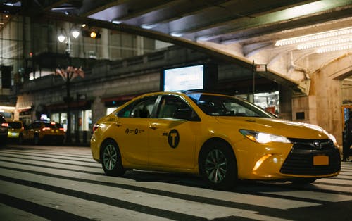 闪亮的老式出租车与夜间在道路上行驶的发光大灯 · 免费素材图片