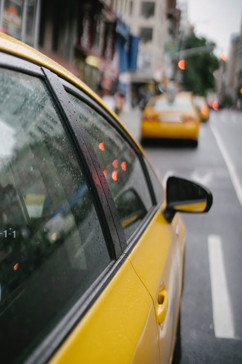黄色出租车沿着大都市的繁忙道路骑 · 免费素材图片